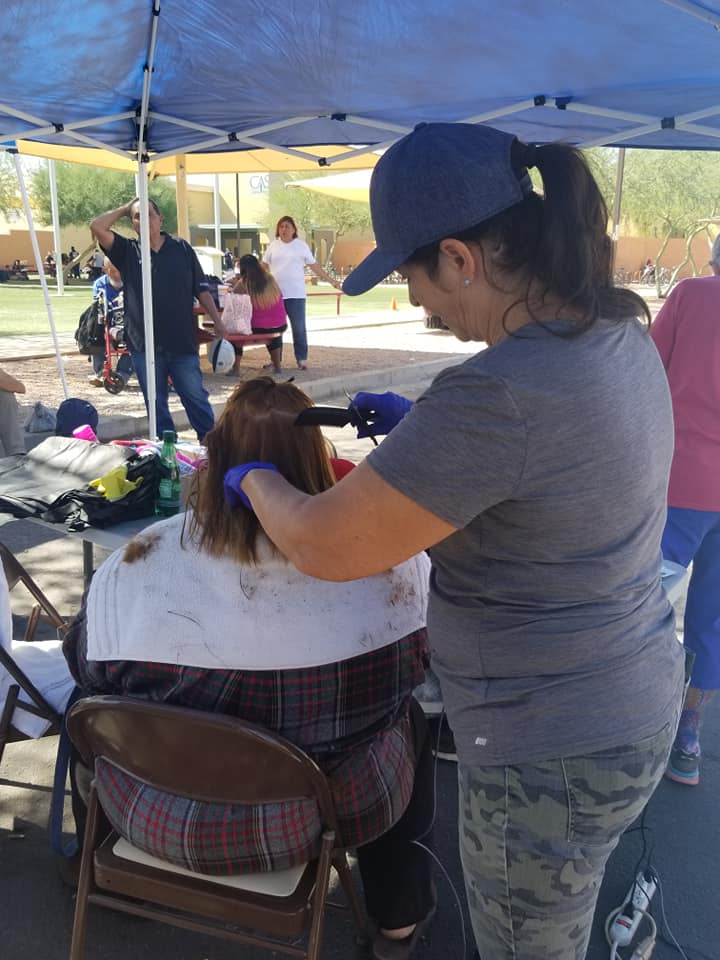 a volunteer cutting hair at a healing cross event